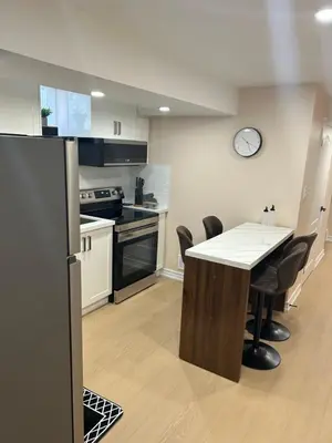 a kitchen with a table and chairs and a clock at North Brampton Getaway in Brampton