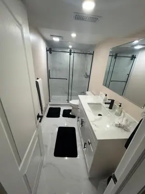 a white bathroom with a shower and a sink at North Brampton Getaway in Brampton
