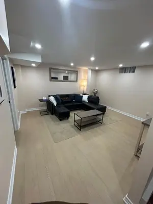 a living room with a black couch and a table at North Brampton Getaway in Brampton