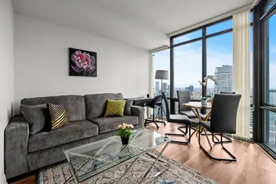 a living room with a couch and a glass table at Attractive 1 Bedroom High Floor with Skyline View in Toronto