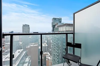 a chair on the top of a building with a city at Attractive 1 Bedroom High Floor with Skyline View in Toronto