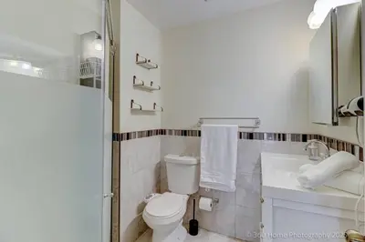 a white bathroom with a toilet and a sink at Prestige Manor, 6BR with Sunroom and 3400 Sqft by Instant Suites in Mississauga