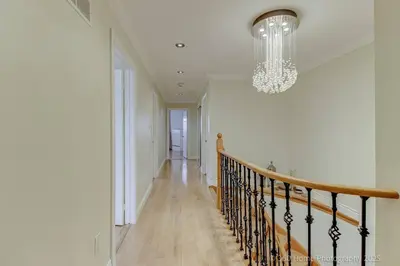 a hallway with a staircase and a chandelier at Prestige Manor, 6BR with Sunroom and 3400 Sqft by Instant Suites in Mississauga