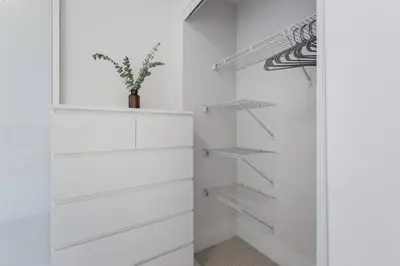 a white walk in closet with white drawers at Modern Down Town Condo Near CN Tower with Fast WiFi in Toronto