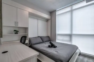a small room with a bed and a window at Down Town CN Tower View 2BR Condo with Balcony and WiFi in Toronto
