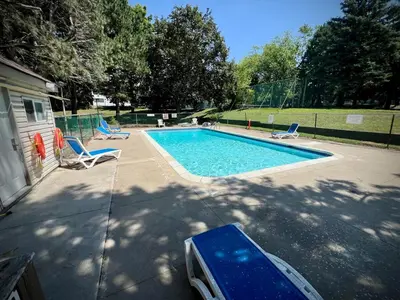 a swimming pool with two lounge chairs next to it at Lower Penthouse Suite with Pools & Sunset Views in Toronto
