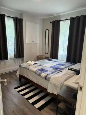 a bedroom with a bed with a blue and white blanket at Comfortable waterfront vacation Keswick in Georgina