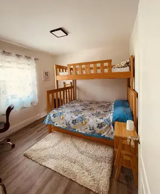 a bedroom with a bunk bed and a desk at Comfortable waterfront vacation Keswick in Georgina