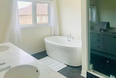 a bathroom with a tub and a toilet and a sink at Beautiful Brand New House in Keswick 8 guests in Georgina
