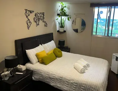 a bedroom with a bed with green and white pillows at DT Apt great view whit garden in Toronto