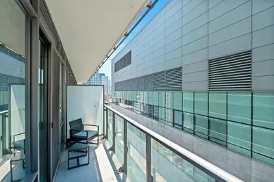 a chair on the balcony of a building at Premium 1 Bedroom with City View in Toronto