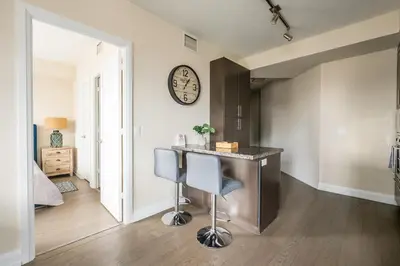 a kitchen with a counter and a clock on the wall at Stylish 2 BR & Den 2BA with Free Parking in Toronto