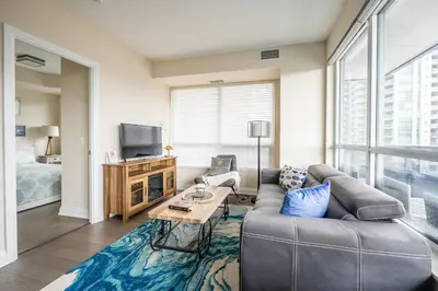 a living room with a couch and a tv at Stylish 2 BR & Den 2BA with Free Parking in Toronto