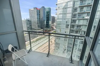 a balcony with a chair and a view of a city at High Floor 1 Bedroom plus Den Condo Iceboat Terrace Downtown Toronto in Toronto