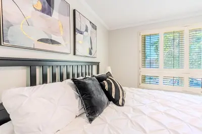 a bedroom with a white bed with black pillows at Family-Friendly 2BR - Sleeps 6 in Hamilton