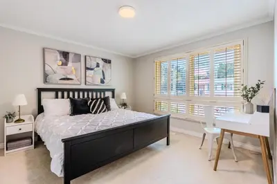 a bedroom with a bed and a desk and windows at Family-Friendly 2BR - Sleeps 6 in Hamilton