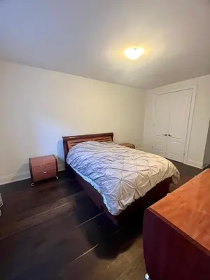 a bedroom with a bed and a wooden floor at Secret Garden in Nobleton