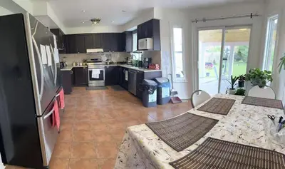 a kitchen with black cabinets and a tile floor at Bright private single bedroom V02 on second floor in Mississauga