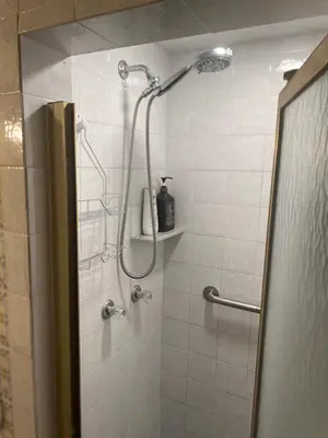 a shower with a shower head in a bathroom at Bright & Cozy Bankfield Stay in Toronto