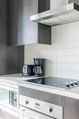 a white kitchen with a stove top oven at 1 Bedroom 26 Floor DT near CN Tower in Toronto