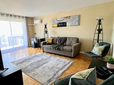 a living room with a couch and a table at Bright 2 BR pet friendly, KING bed, WiFi,2 parking in Kitchener