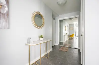 a hallway with a table and a mirror on the wall at Sunshiny 1 BD 61st Floor Outstanding View in Toronto