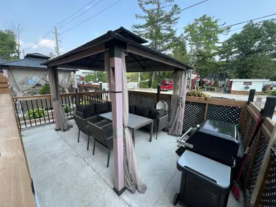 a gazebo with chairs and a table on a deck at Adrian's Suites 2 Bedroom FamilySuite in Wasaga Beach