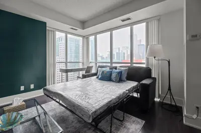 a bedroom with a bed and a large window at Elegant 1 Bedroom in Downtown Toronto in Toronto