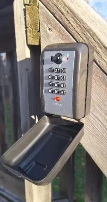 a cell phone holder on a wooden bench at Century House on Quarter acre lot in Acton