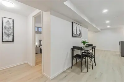 a dining room with a table and chairs in a white room at Stewarts Place Newly Renovated Basement City Apartment in Hamilton