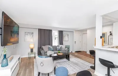 a living room with a couch and a table at Quaint and Stylish UPPER level 3-bed bungalow in Hamilton, ON in Hamilton
