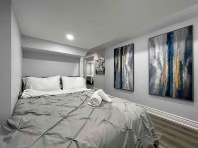a bedroom with a large bed with two paintings on the wall at Elegant Oakville Town Residece in Oakville