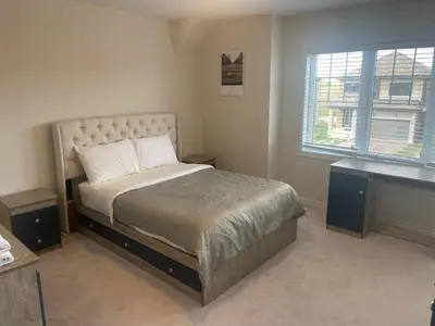 a bedroom with a bed and a desk and a window at New 3 Bedroom 2 Bathroom Home in West Niagara in Thorold