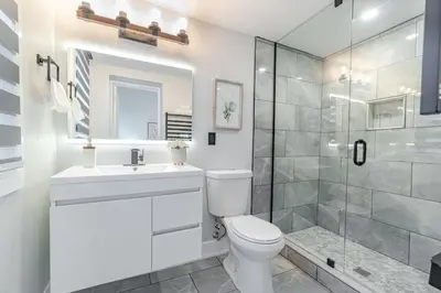 a bathroom with a toilet and a glass shower at The Millertime Experience in Brantford