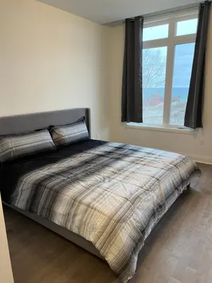 a bedroom with a large bed with a window at Bowmanville Room in Bowmanville