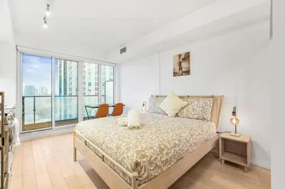 a bedroom with a bed and a large window at 251 Jarvis st -Steps to Eaton Centre - Monthly Stays Only in Toronto