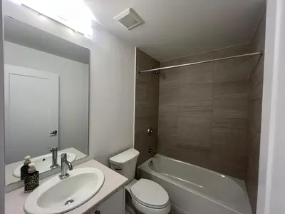 a bathroom with a sink and a toilet and a tub at Stylish 2-Story Condo with Balcony in Kitchener