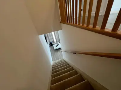 a stairway with a wooden railing and a stair case at Stylish 2-Story Condo with Balcony in Kitchener