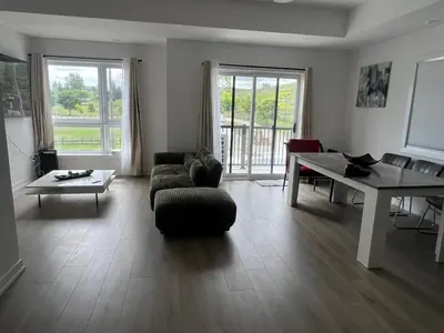 a living room with a couch and a table at Stylish 2-Story Condo with Balcony in Kitchener
