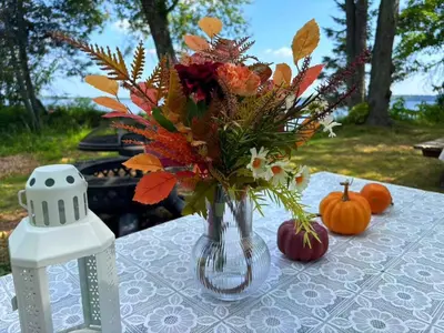 a vase of flowers on a table with pumpkins at Pet friendly- Crystal Water fishing Family Retreat in Havelock
