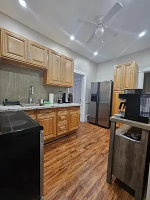 a kitchen with wooden cabinets and a refrigerator at King Comfort Retreat in Peterborough