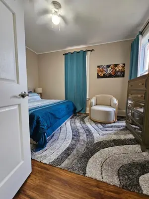 a bedroom with a bed and a chair at King Comfort Retreat in Peterborough