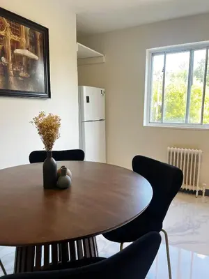 a dining room table with chairs and a vase on it at Upper Beaches Apartment in Toronto