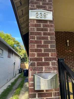 a brick pole with a sign on the side of a house at Toronto Upper Beaches Apartment in Toronto
