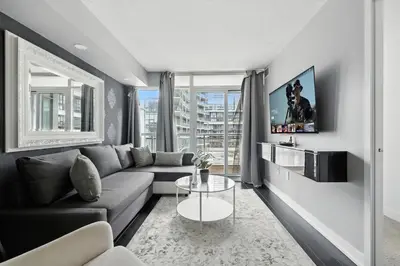 a living room with a couch and a table at Stylish DT Condo with Vanity Mirror, Free Parking! in Toronto