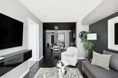 a living room with a couch and a tv at Stylish DT Condo with Vanity Mirror, Free Parking! in Toronto