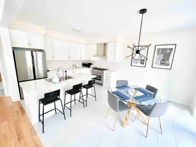 a kitchen and dining room with a table and chairs at Two Adjacent Modern Homes in West Niagara Sleep 16 in Thorold