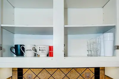 a shelf with cups and mugs on it at Winter Family Retreat-Snow Play & Ski Hills Nearby in Barrie