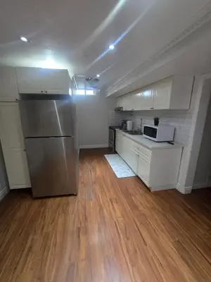 a kitchen with white cabinets and a stainless steel refrigerator at Private in Mississauga