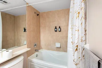 a bathroom with a tub and a shower curtain at SkyView 2BR Plus Den Stunning Views Steps to SQ1 Mall in Mississauga